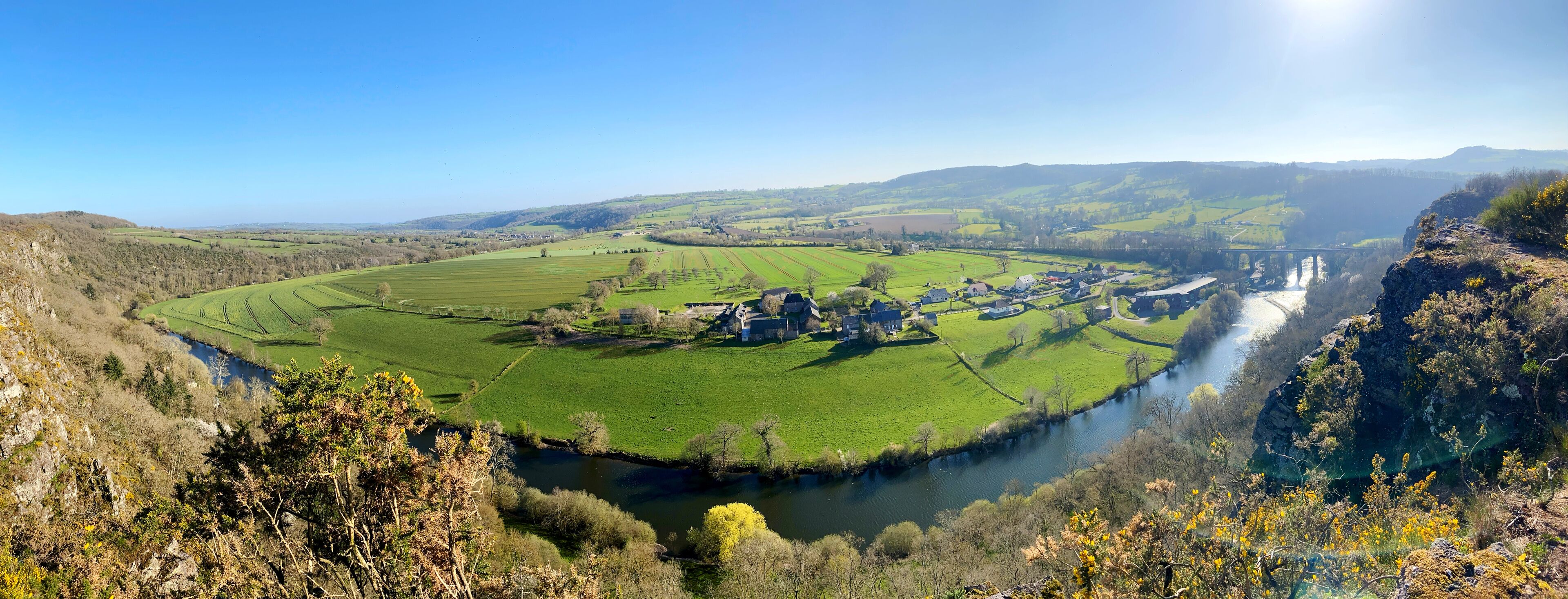 A river winding through a valley with fields and a small village.