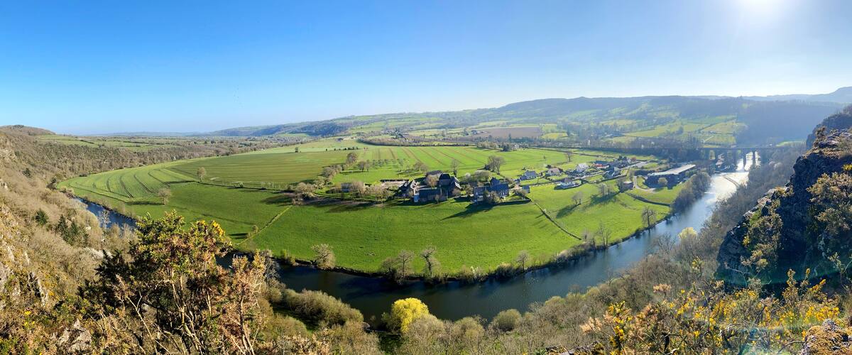 A river winding through a valley with fields and a small village.