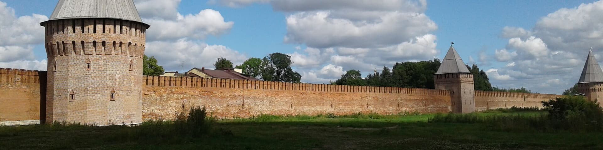 A historic fort with two prominent towers and a brick wall.