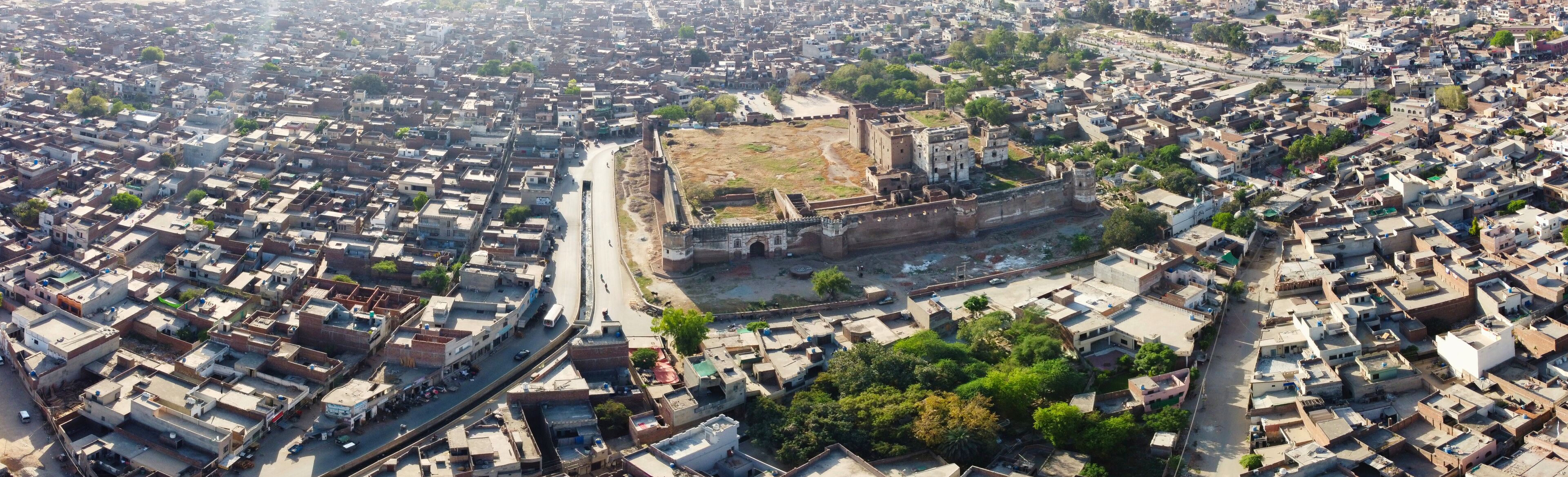 An aerial view of a densely packed urban area with a prominent historical fort surrounded by residential buildings.