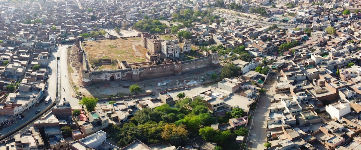 An aerial view of a densely packed urban area with a prominent historical fort surrounded by residential buildings.