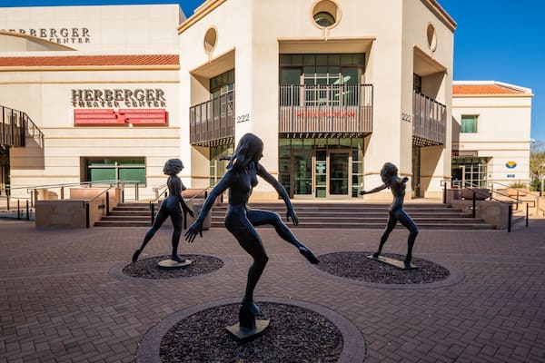 A theater building with a sign reading "Herberger Theater Center" and three statues of dancers in front.