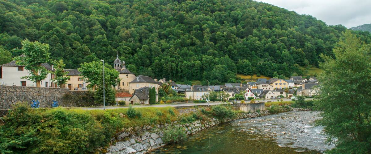 A river flowing through a village with houses and a church.