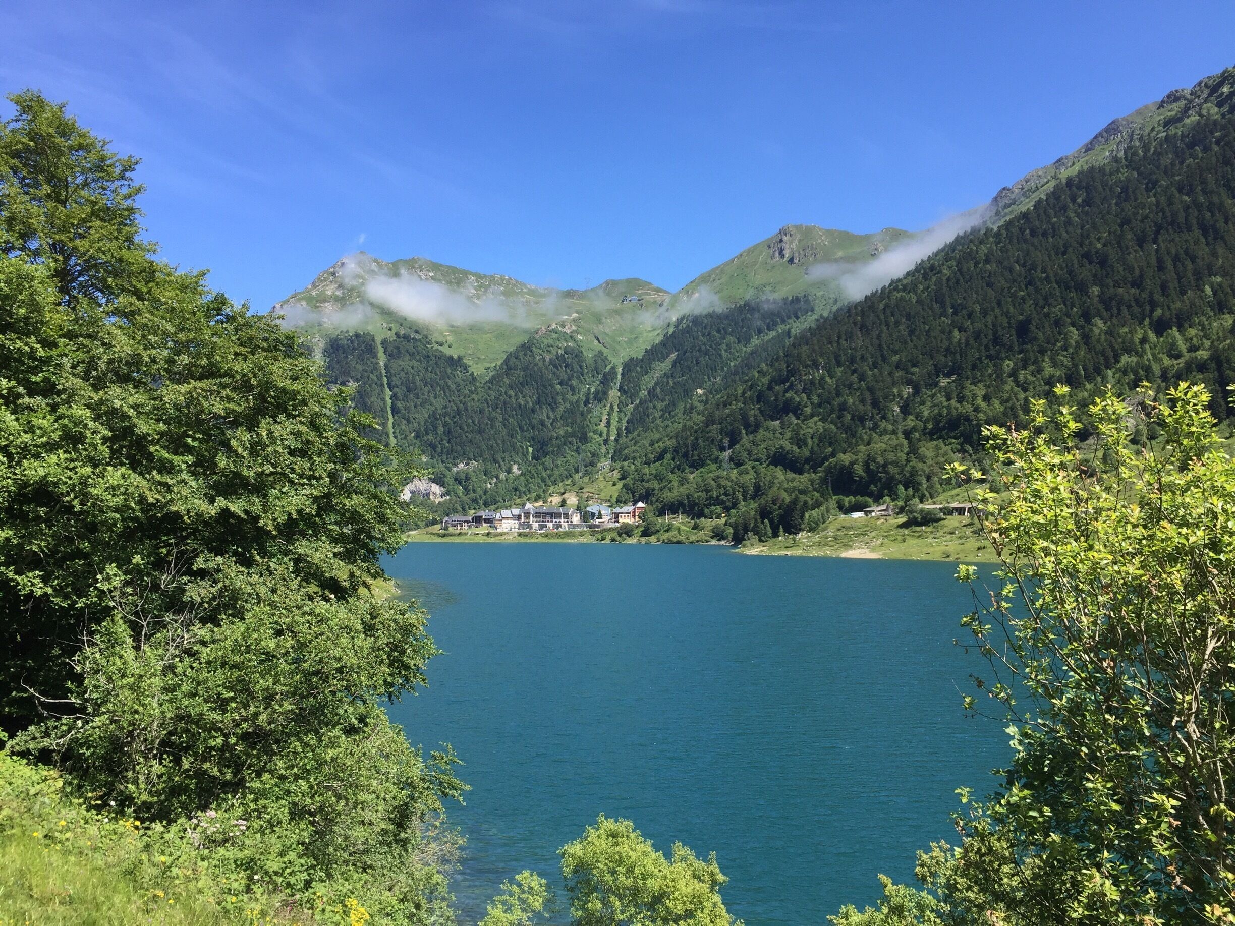 A lake surrounded by lush green hills and mountains.