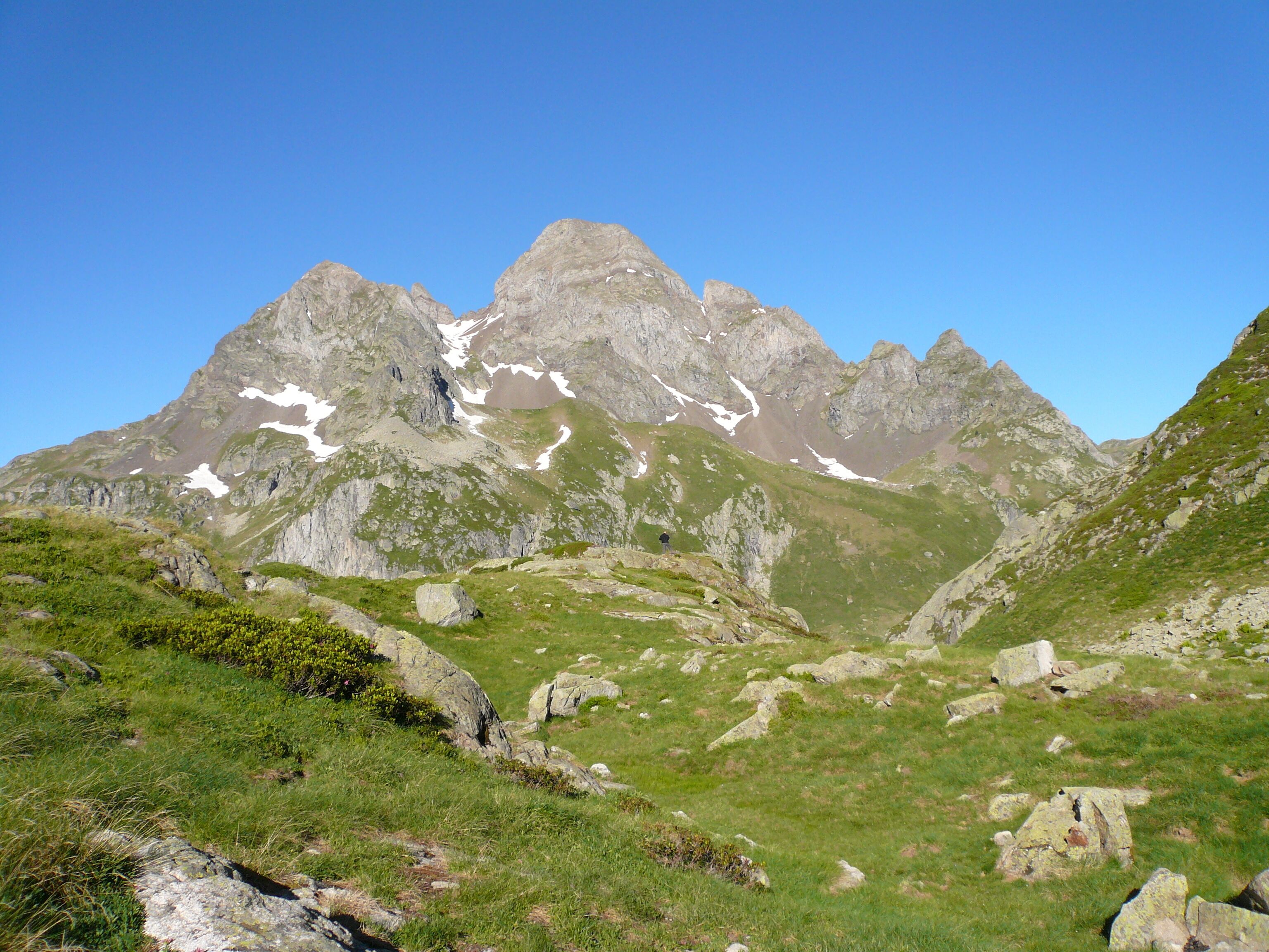 A mountainous landscape with rocky peaks and patches of snow.
