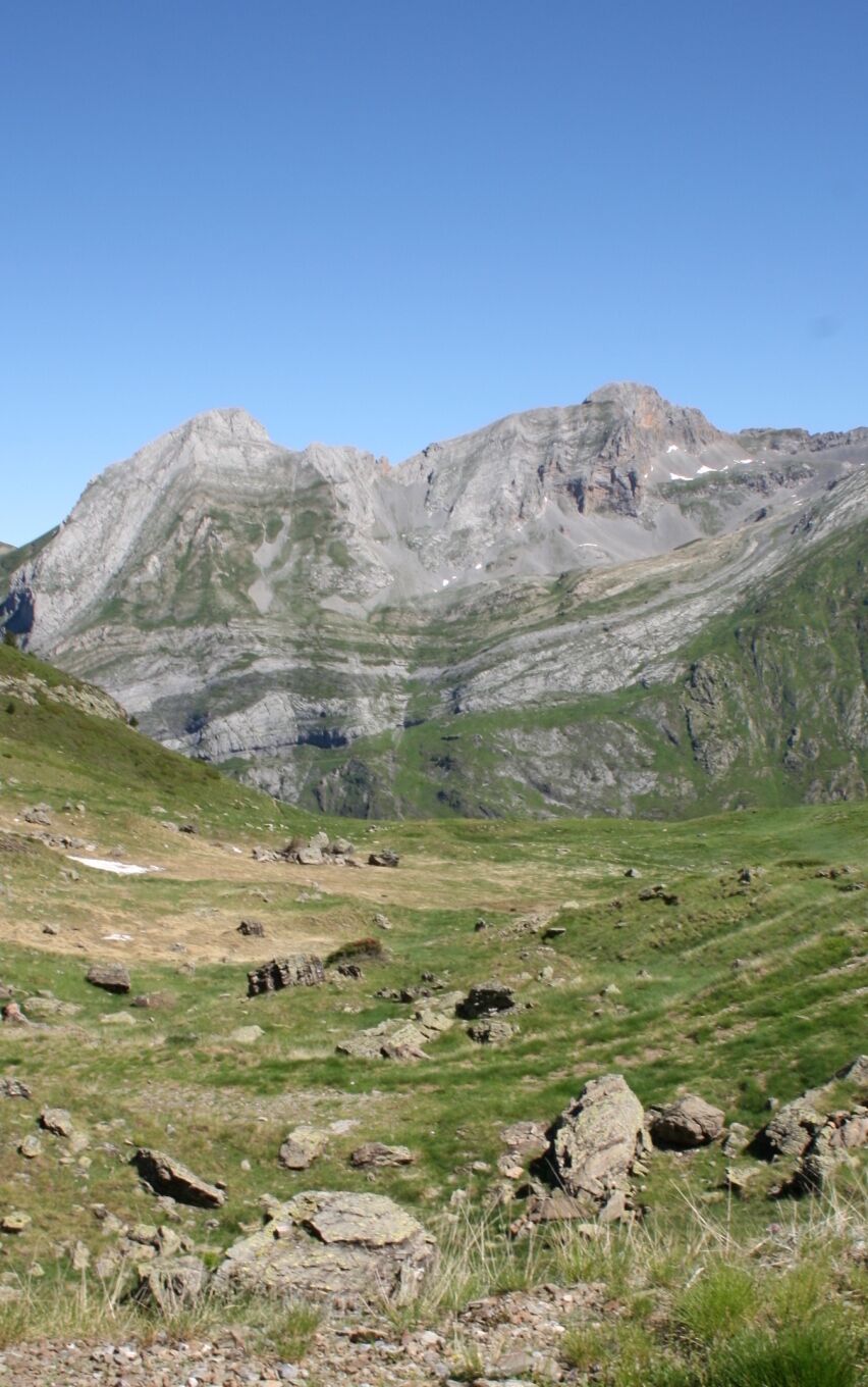 A mountainous landscape with rocky terrain and patches of grass.