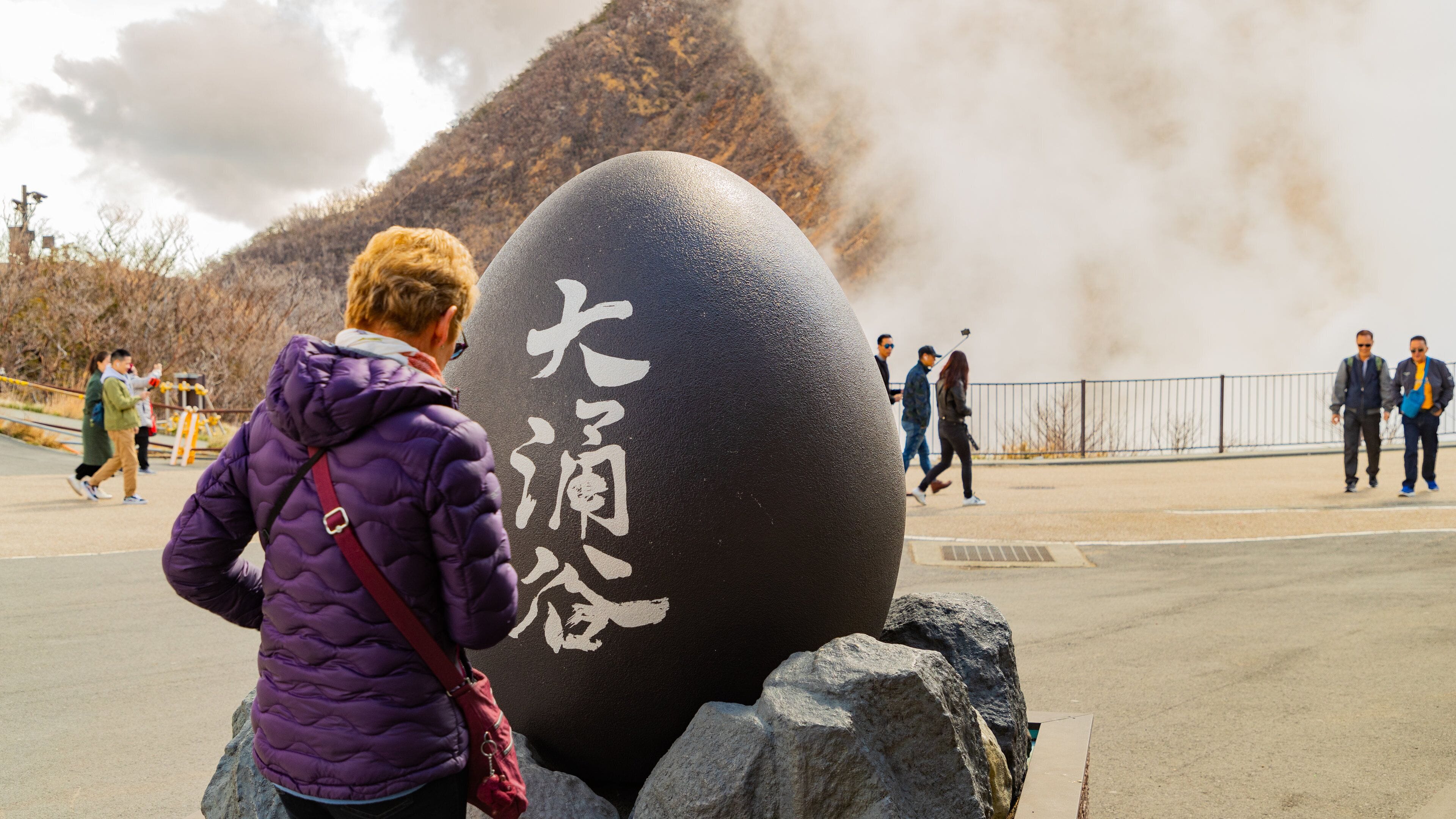 Ōwakudani which includes mist or fog and signage as well as an individual femail