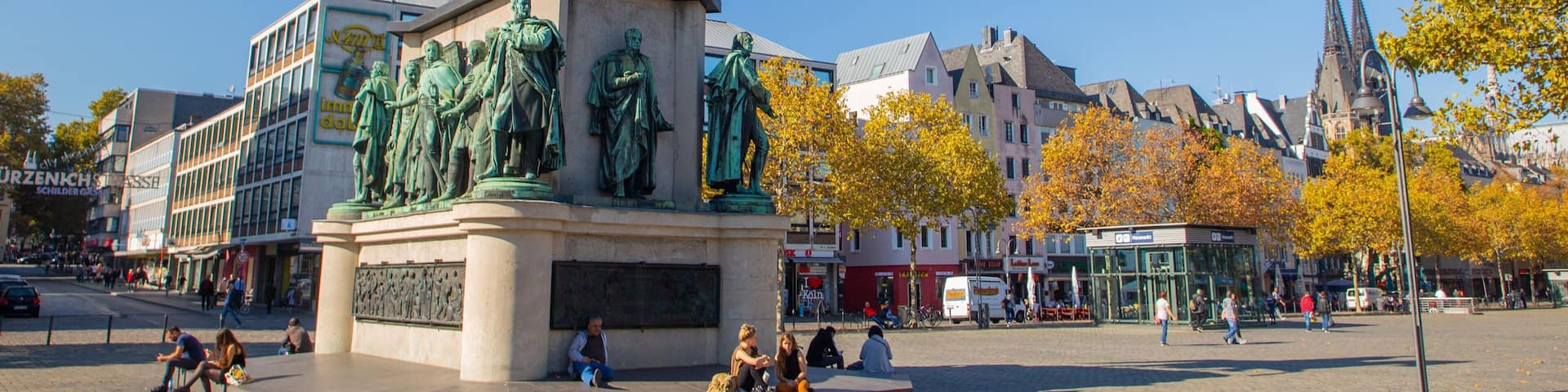 A statue of a man on horseback in a public square with buildings and trees in the background.