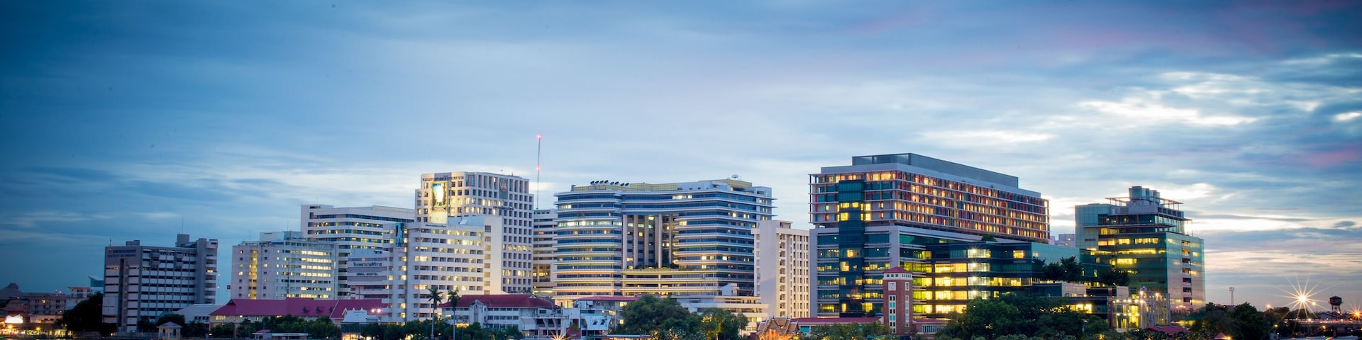Siriraj Hospital A major government hospital in Bangkok, Thailand situated by the Chao Phraya River with twilight light.