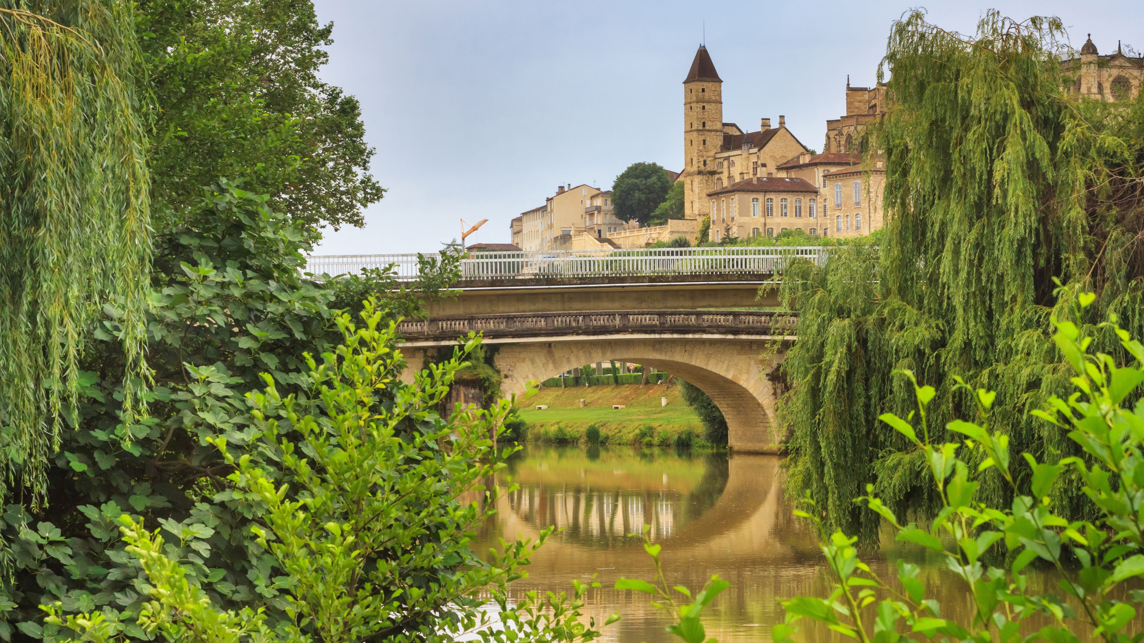 Un pont de pierre enjambant une rivière, avec un château en arrière-plan.