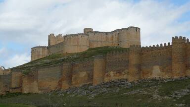 A large medieval castle with multiple towers and a thick stone wall.