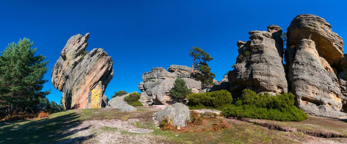 A landscape with prominent rock formations and scattered trees.