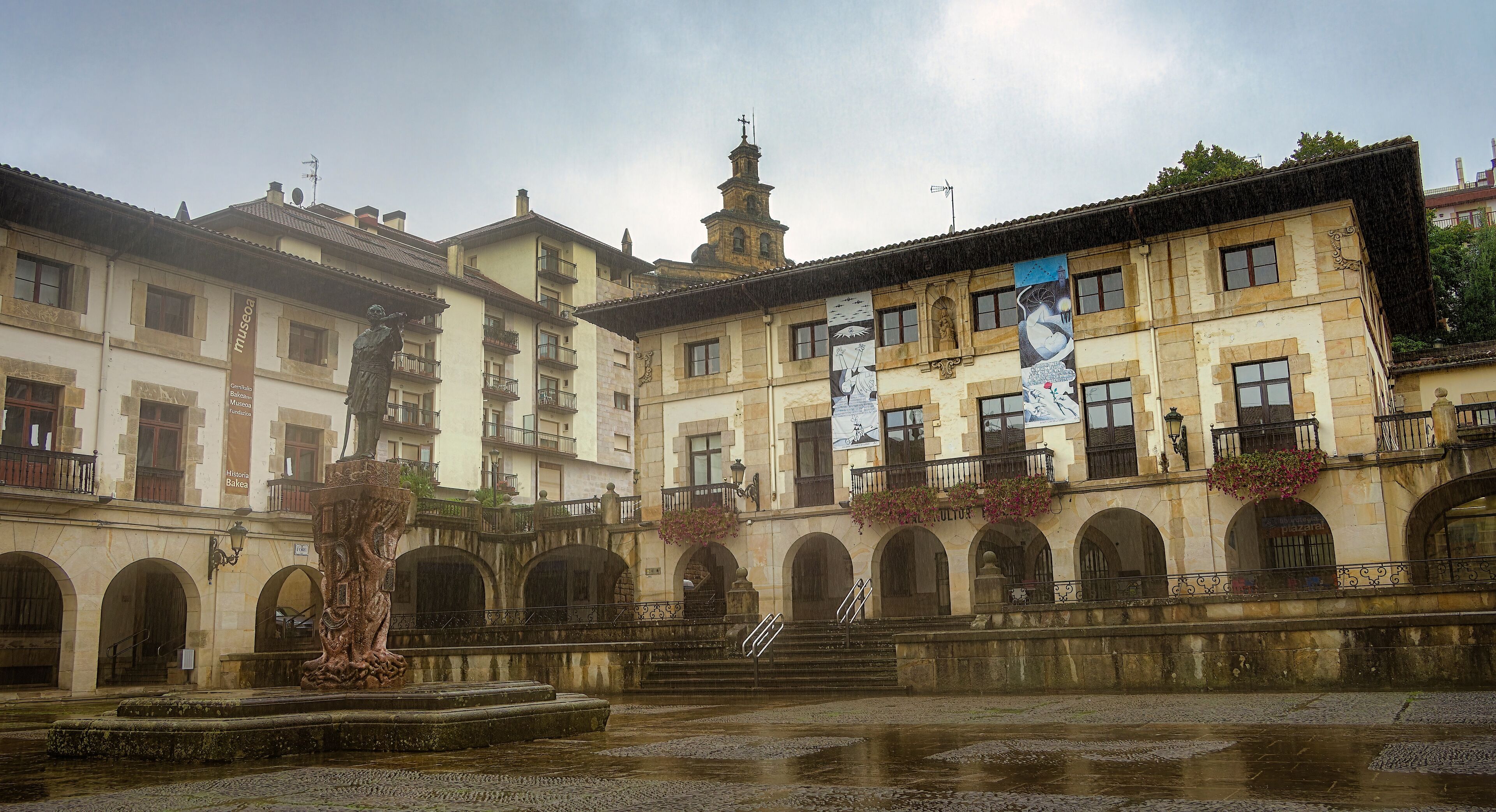 A historic building with arched windows and a fountain in the courtyard.