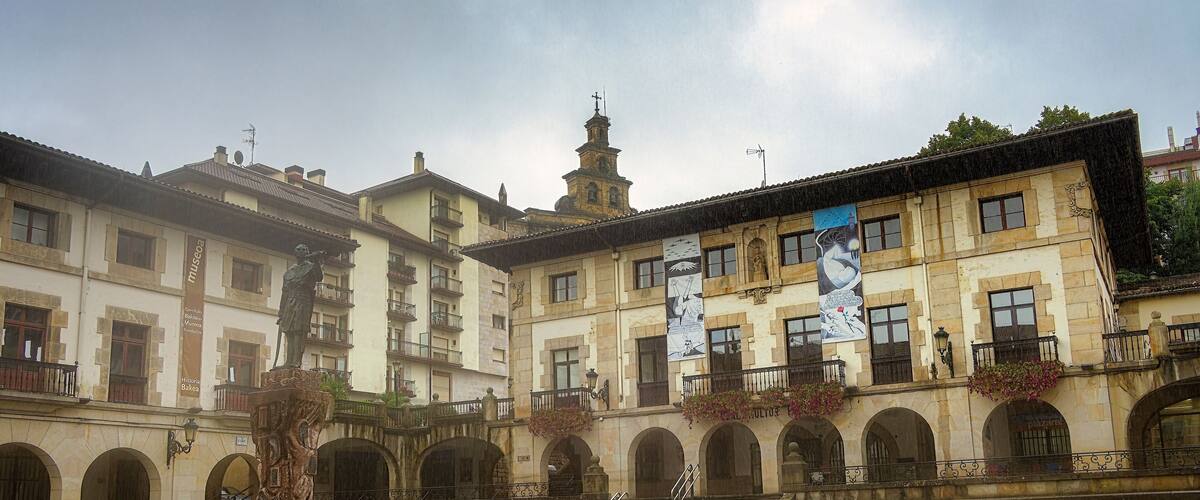 A historic building with arched windows and a fountain in the courtyard.