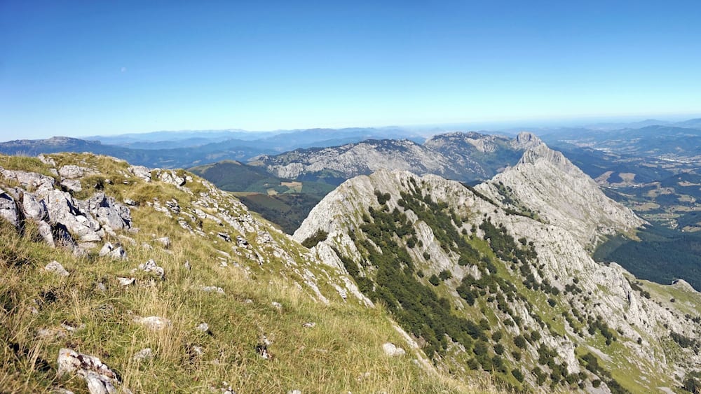 Un paysage montagneux, avec des pics rocheux et une vallée en contrebas.