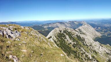 A mountainous landscape with rocky peaks and a valley below.