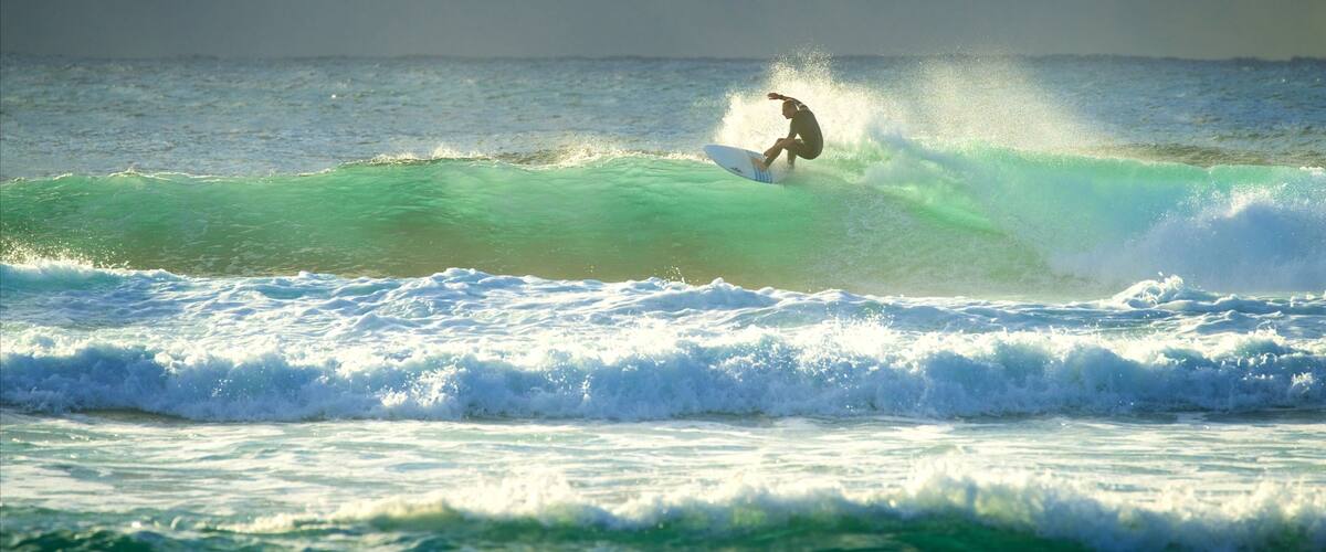 A surfer riding a wave in the ocean.