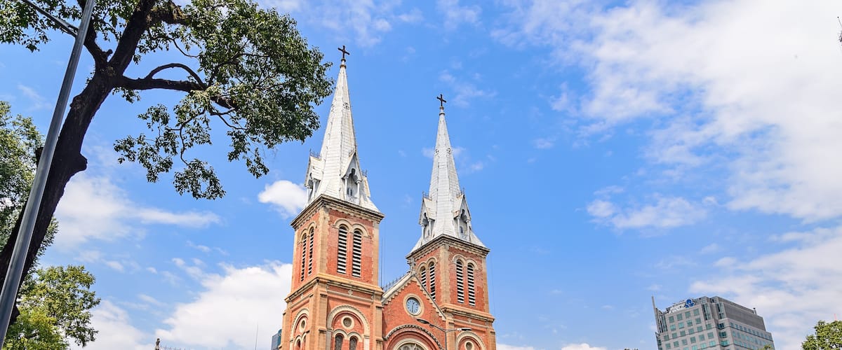 Saigon Notre-Dame Cathedral Basilica (Basilica of Our Lady of The Immaculate Conception) on blue sky background in Ho Chi Minh city, Vietnam. Ho Chi Minh is a popular tourist destination of Asia.; Shu