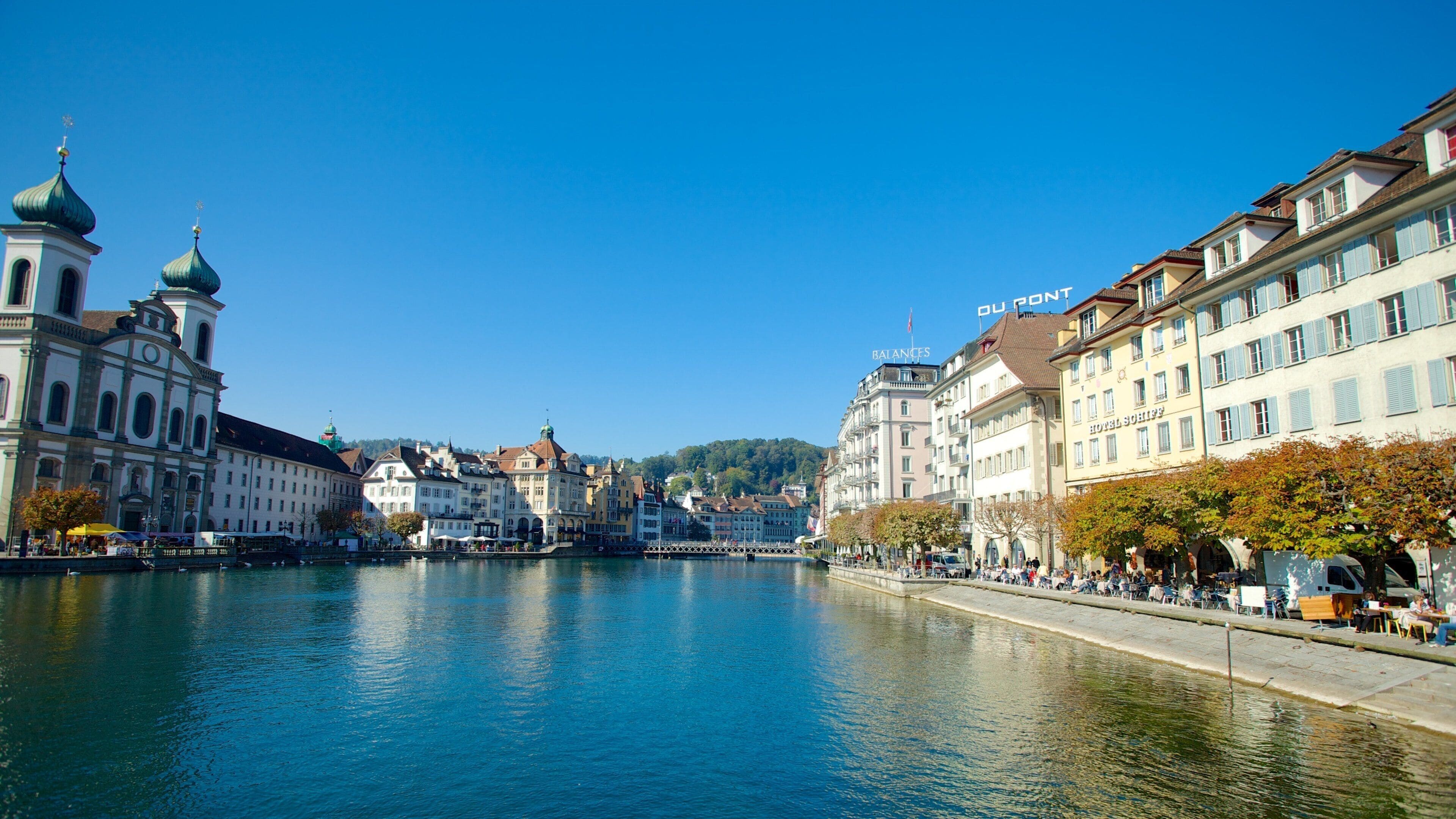 Ein Fluss, der von Gebäuden gesäumt ist, darunter ein Hotel und eine Kirche.