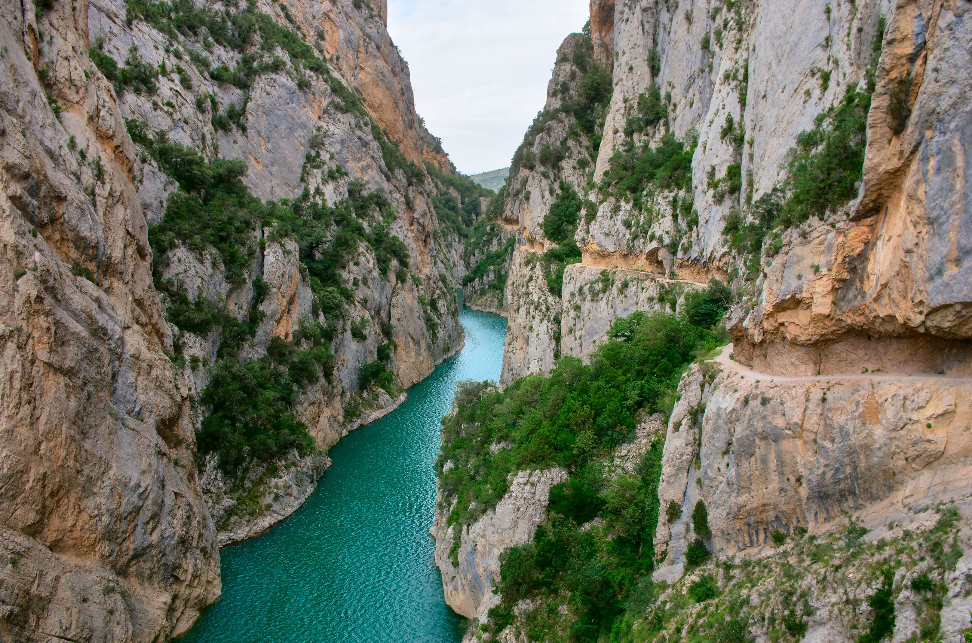 A canyon with a turquoise river and rocky cliffs.