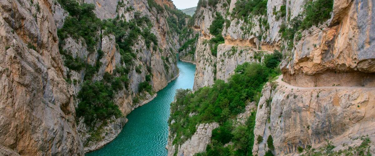A canyon with a turquoise river and rocky cliffs.