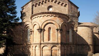A historic stone building with arches and a circular window.