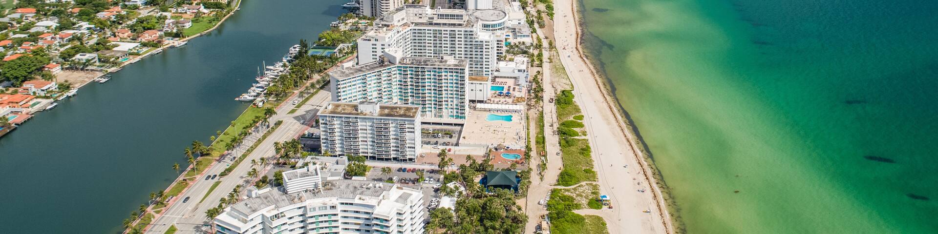 Aerial Miami Beach along Collins Avenue mid beach waterway with Yacht Marina and high rise condos
