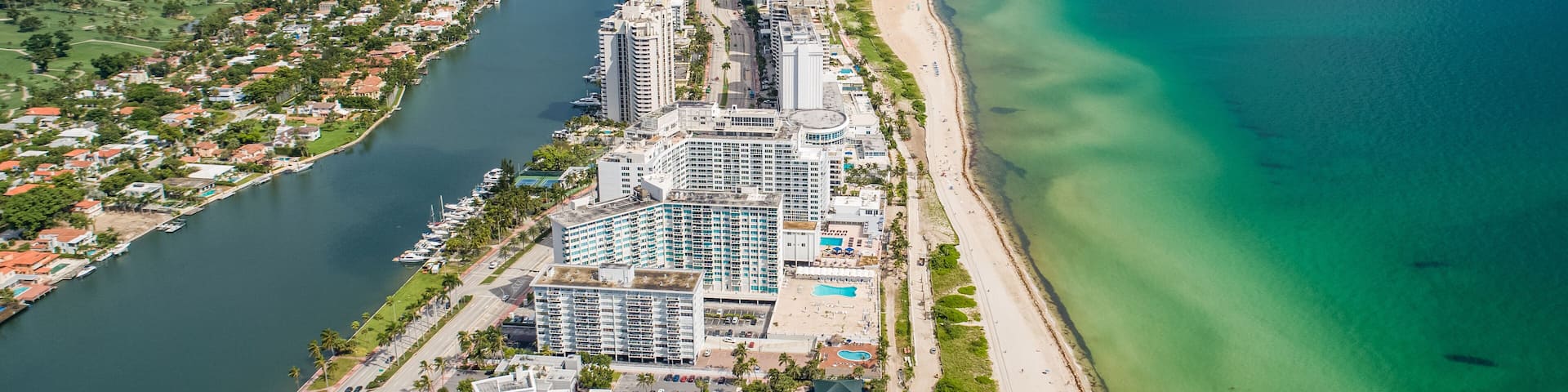 Aerial Miami Beach along Collins Avenue mid beach waterway with Yacht Marina and high rise condos