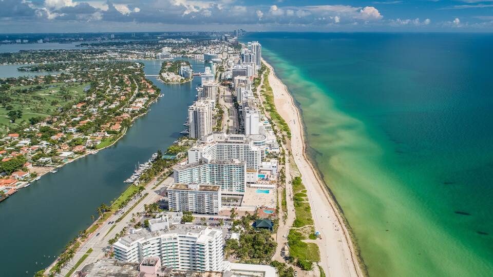 Aerial Miami Beach along Collins Avenue mid beach waterway with Yacht Marina and high rise condos