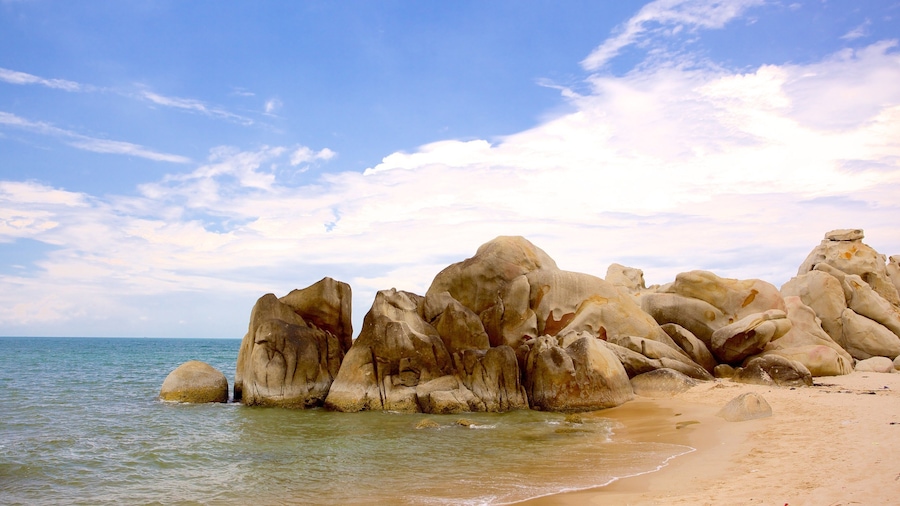 A rocky coastline with large boulders and a clear sky.