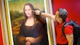 A person pointing at the Mona Lisa painting.