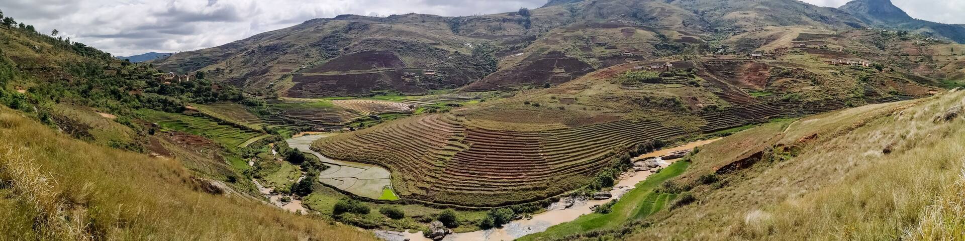 Wide Panorama Rice terrace fields on small hills with clay houses near national park Andringitra National park in central Madagascar near Tsaranoro valley