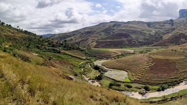 Wide Panorama Rice terrace fields on small hills with clay houses near national park Andringitra National park in central Madagascar near Tsaranoro valley