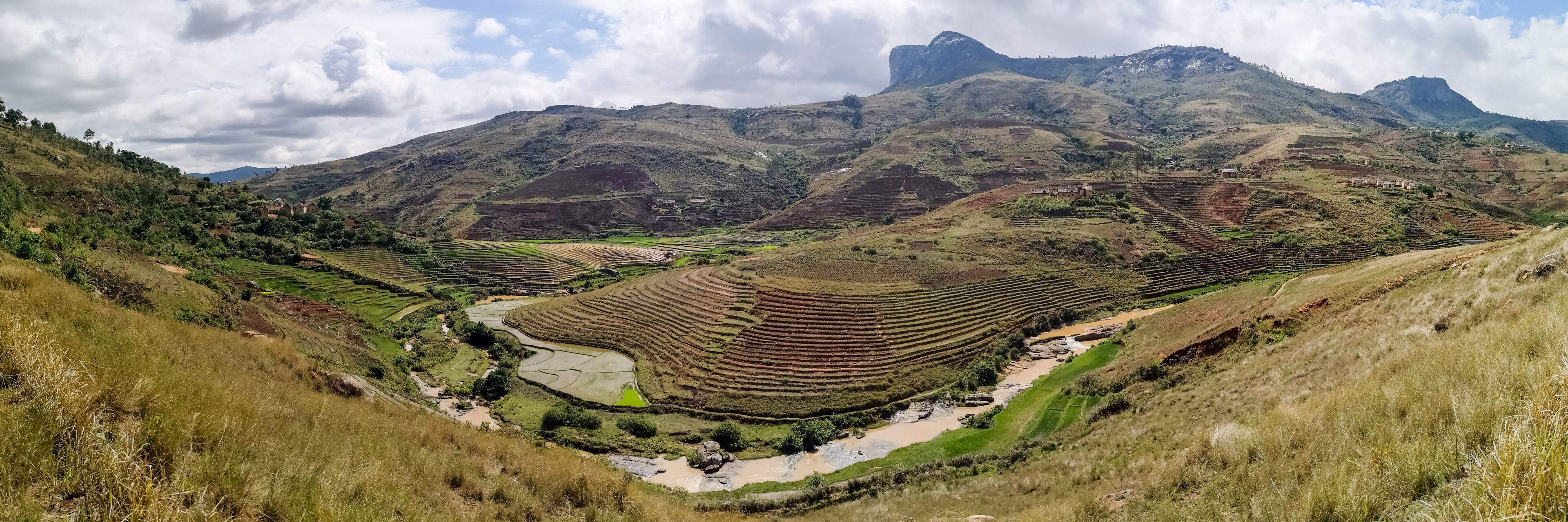 Terraced rice fields, a river, and mountains.
