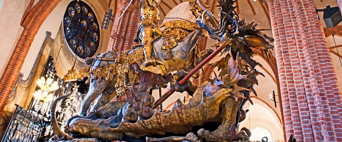 A detailed sculpture of a knight on a horse in a cathedral.