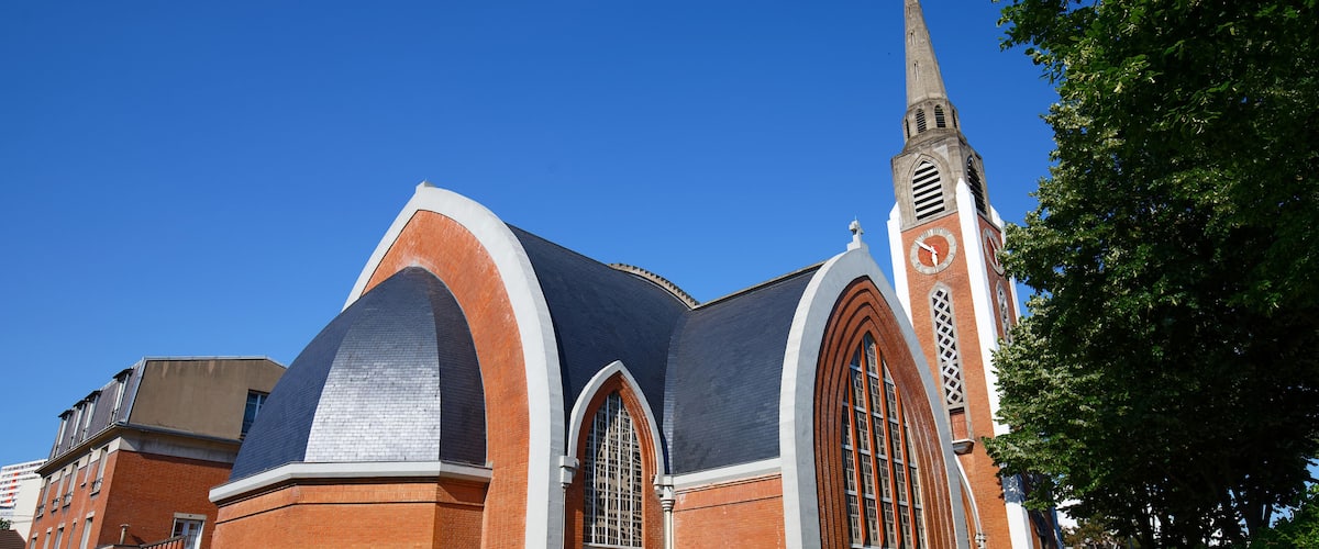 A church with a tall steeple and a clock tower.