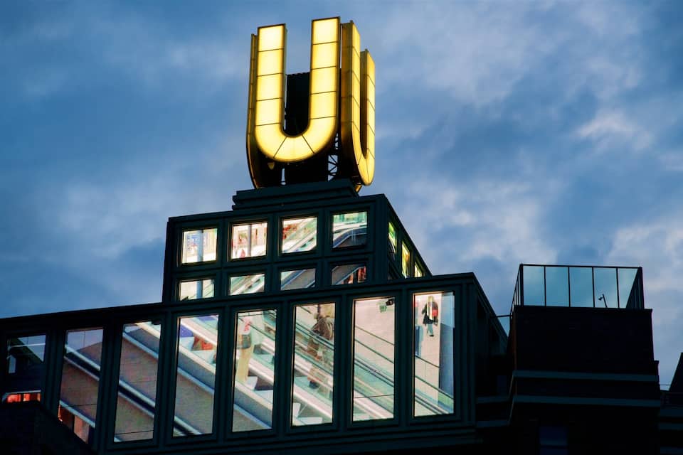 A building with a large illuminated 'U' sign on top and multiple windows.