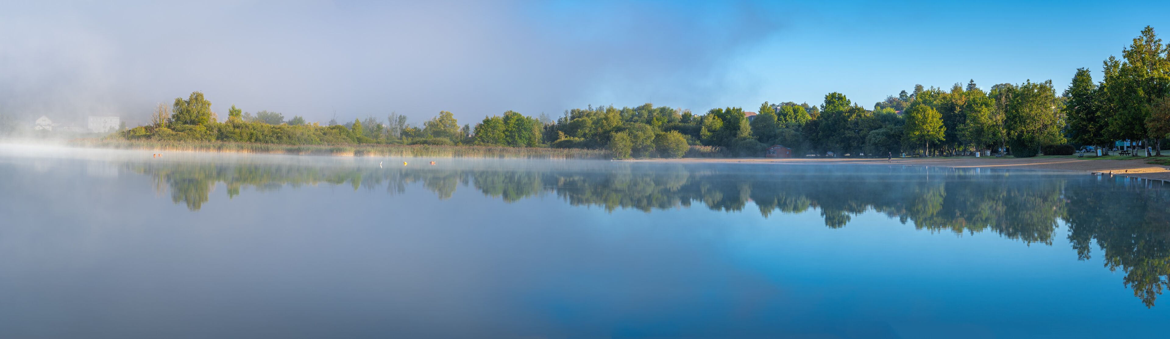 Clairvaux-Les-Lacs, France - 09 02 2020: Fog and reflections on the big lake - La Raillette