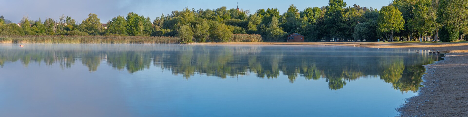 Clairvaux-Les-Lacs, France - 09 02 2020: Fog and reflections on the big lake - La Raillette
