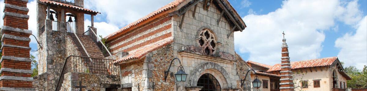 An old church with a bell tower, a stone facade, and a large arched entrance.