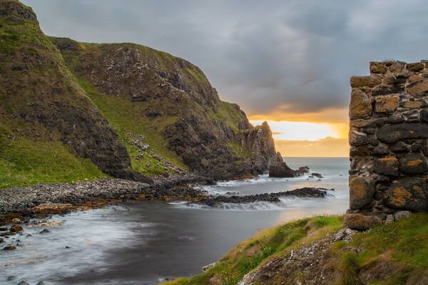 Kinbane Castle featuring a sunset, a river or creek and rocky coastline