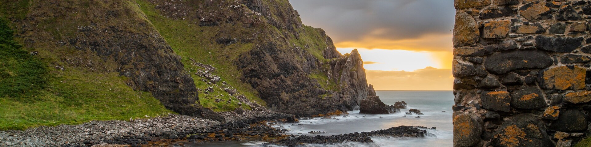 Kinbane Castle featuring a sunset, a river or creek and rocky coastline