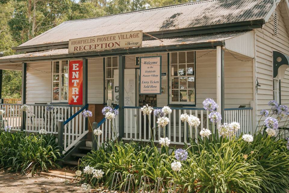 A rustic building with a sign reading "Highfields Pioneer Village Reception."