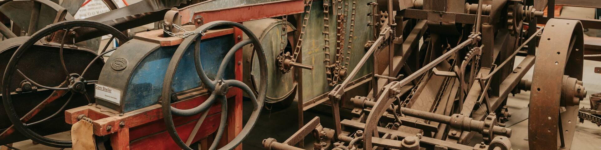 Entorno industrial con maquinaria, incluyendo una máquina desgranadora de maíz, engranajes y cadenas varios.