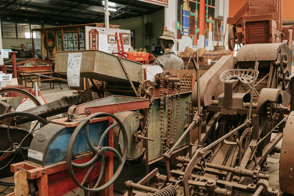 An industrial setting with machinery, including a corn sheller and various gears and chains.