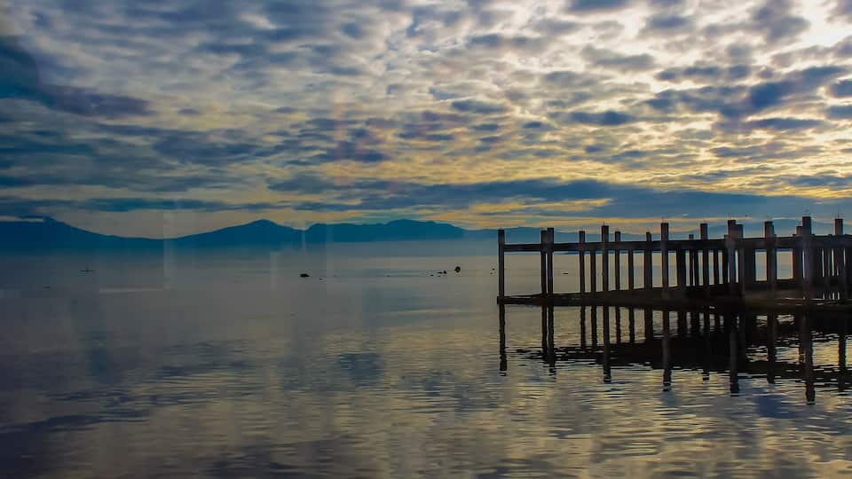 A calm lake with a wooden pier extending into the water.