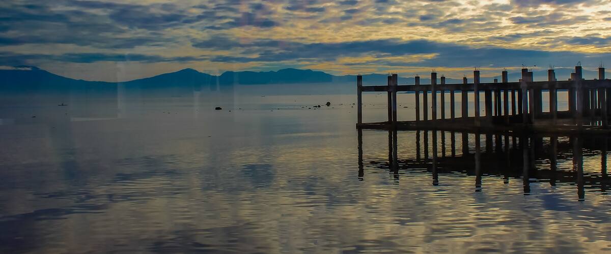 A calm lake with a wooden pier extending into the water.
