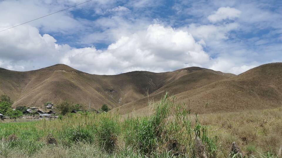 A mountainous landscape with a village nestled among the hills.