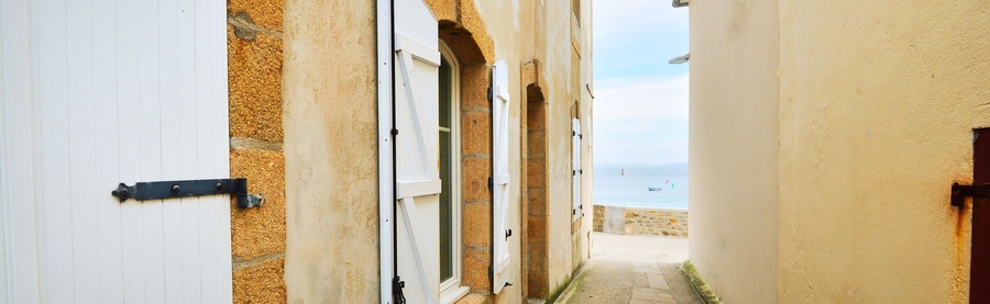 Narrow street passage at Ile de Sein, France. Panoramic view. Old traditional houses close-up. Travel destinations, vacations, landmarks, sightseeing, architecture