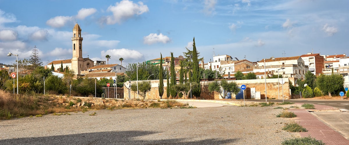 A coastal town with a prominent church tower, a mix of residential buildings, and a clear sky.